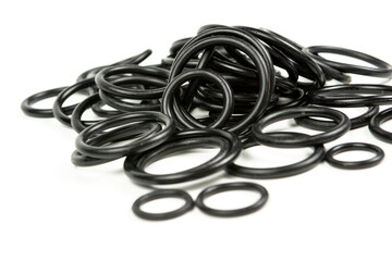 Hydraulic and pneumatic o-rings in black in different sizes on a white background. Various seals for plumbing. Sealing rings for hydraulic connections.