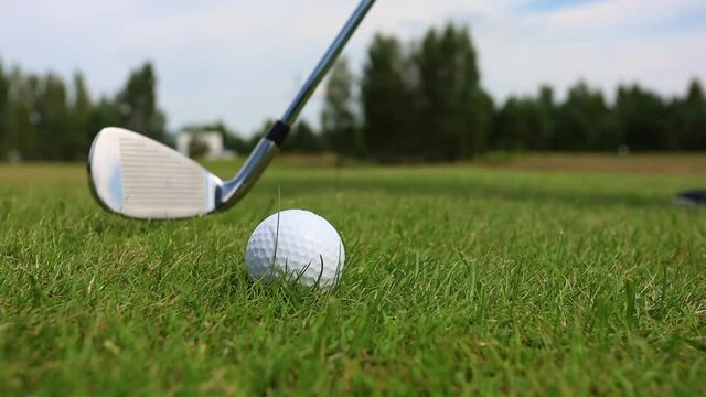 Close-up of hitting a golf club on the ball against a forest background