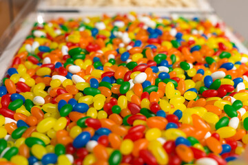 Bright colored small candy dragees yellow green red blue store.