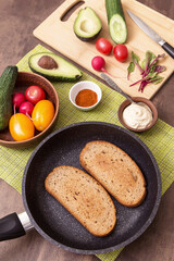 Cooking vegan vegetarian sandwiches, toasts with different vegetables and toasts of fried bread on kitchen. Healthy diet food concept