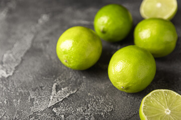 Lime, juicy ripe citrus fruits on a dark background. Ingredients for preparing refreshing drinks and cocktails. Mojito. Selective focus, top view and copy space