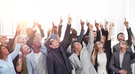 group of diverse business people pointing somewhere up.