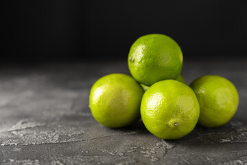 Lime, juicy ripe citrus fruits on a dark background. Ingredients for preparing refreshing drinks and cocktails. Mojito. Selective focus, top view and copy space