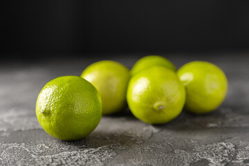 Lime, juicy ripe citrus fruits on a dark background. Ingredients for preparing refreshing drinks and cocktails. Mojito. Selective focus, top view and copy space