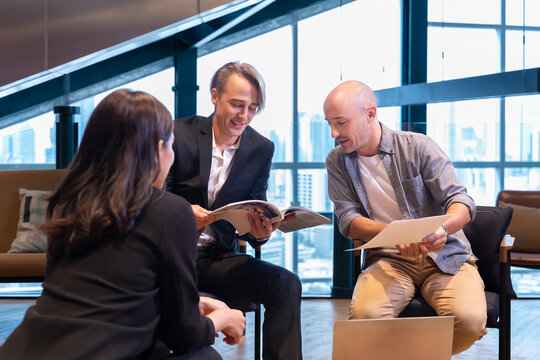 Team of Caucasian designer is discussing with the client for new advertisement in magazine for branding and creative promotion project concept