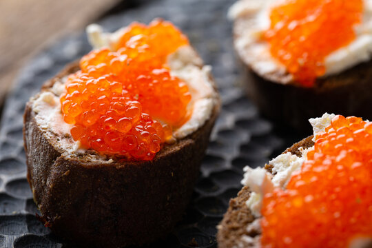 Appetizer with red caviar, cream cheese and rye bread
