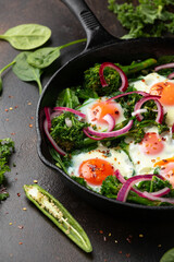Green shakshuka with golden yolk eggs, kale, spinach and tender broccoli served with pickled onions and chilli flakes