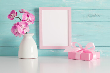Beautiful flowers composition. Photo frame, gift pink, orchid flower on pastel turquoise background. Valentines Day, Happy Women's Day. 