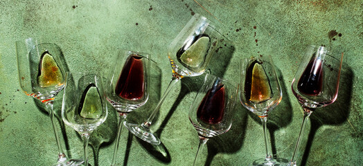 Red, rose and white wine in glasses on rusty green background, top view. Wine bar, shop, winery,...