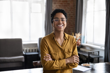 Fototapeta premium Happy cheerful young African business woman, entrepreneur, professional head shot portrait. Millennial short haired female leader, manager, employee profile picture. Corporate worker looking at camera