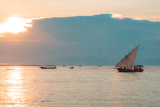 Fishing ship and boats in water of Indian ocean on a scenic sunset. Zanzibar, Tanzania