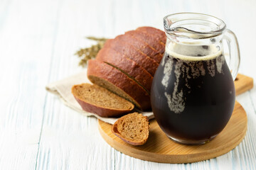 Refreshing fizzy summer drink, rye bread kvas on wooden background. Space for text.