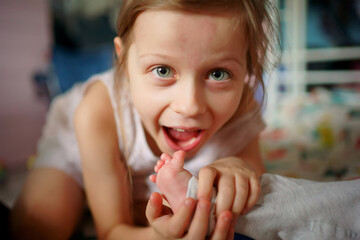 Girl playing with her baby sister. Selective focus, shallow depth of field. High quality photo