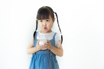 Portrait cute smiling Asian girl holding a glass of milk with white background..
