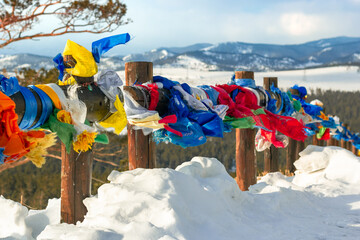Colorful traditional prayer flags hanging out in wind at snowy temple complex at cold winter, spiritual asian culture at local monastery, no people mountain landscape