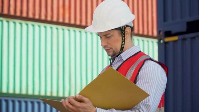Foreman holding document file check list inventory and loading Containers box at warehouse logistic in Cargo . freight ship for import export. engineer and Communication of transportation