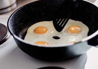 Person preparing fried eggs