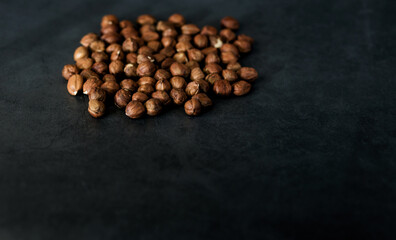 Many hazelnuts on dark backdrop