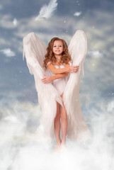 little cute girl with angel wings against the sky on Valentine's Day February 14