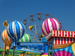 Colourful fairground rides against a blue sky