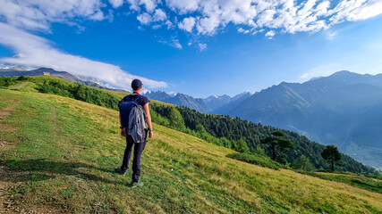 A male hiker enjoying the amazing views on the mountain ridges in the Greater Caucasus Mountain Range in Georgia, Samegrelo-Upper Svaneti Region. Alpine pasture along the path.Wanderlust.Koruldi Lakes