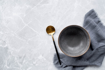 Banner. An empty ceramic plate and towel against the background of a gray concrete table. Space for...