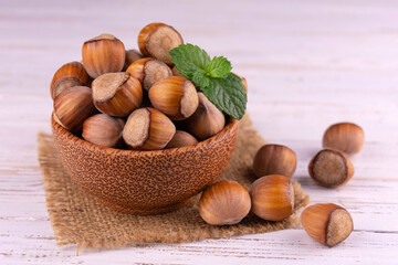 Hazelnuts in a wooden bowl on a white background.Close-up.