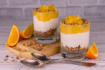 Parfait of orange yogurt and granola in a glass. Healthy low calorie dessert food
