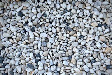 Smooth round pebbles texture background. Pebble sea beach close-up, dark wet pebble and gray dry pebble.