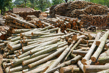 Piles of wood from logging forests to be used as raw materials for furniture. Piles of round and square wood form patterns and textures.