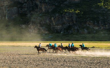 Many riders on horseback play as a team on the field.Traditional Asian game of Kok boru,goat-picking
