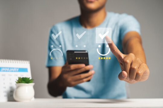 Customer satisfaction survey concept, Man using Smartphone select smiley face icon with yellow five stars