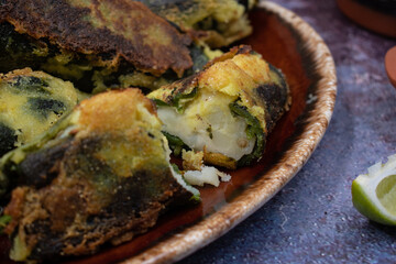 Vegetarian chiles rellenos  served with green chile salsa, sour cream, pickled onion