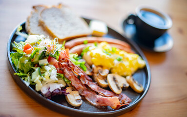 Breakfast with scrambled eggs, bacon, sausages and toast