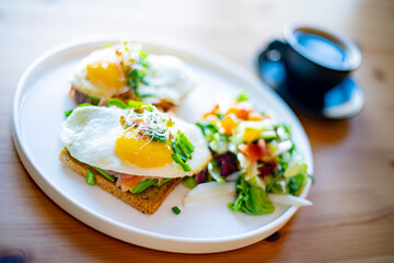 Breakfast with fried eggs on toasts on a restaurant table