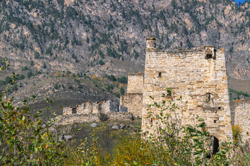 An abandoned medieval town. A complex of towers in the mountains of Ingushetia. Military and residential ancient towers built of stones. Landscape in the mountains with a view of the ruins.