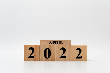 April 2022 written on wooden blocks isolated on white background with copy space