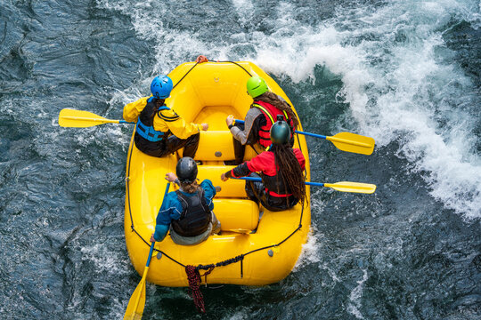People rafting white watered river with yellow raft. Removed all logos. Water sports and adrenaline rush concept.