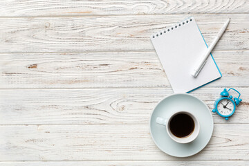 Modern office desk table with notebook and other supplies with cup of coffee. Blank notebook page for you design. Top view, flat lay