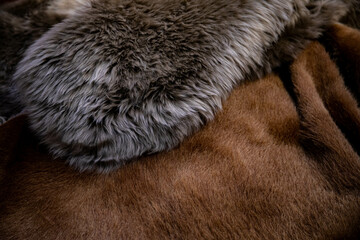 natural animal skins stacked in a pile for sale. cow and sheep skin