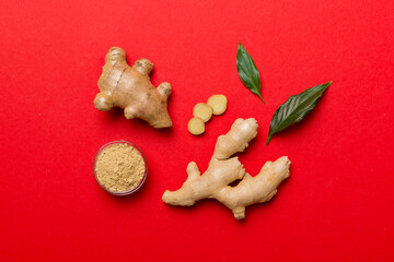 Finely dry Ginger powder in bowl with green leaves isolated on colored background. top view flat lay