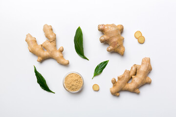 Finely dry Ginger powder in bowl with green leaves isolated on colored background. top view flat lay