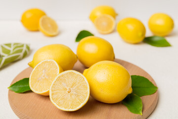 Top view with copy space for fresh and ripe lemons on cutting board. Healthy food background. Elegant background of lemon and lemon slices with squeezer colored background