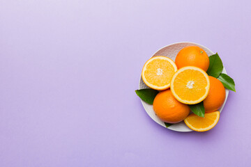 Flat lay of Fresh orange fruit with sliced in plate on Colored background. Top view with copy space