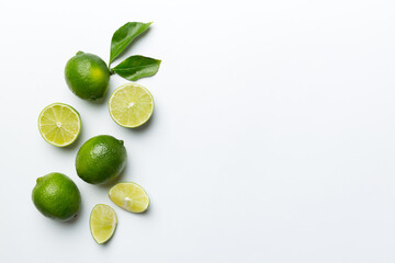 Lime fruits with green leaf and cut in half slice isolated on white background. Top view. Flat lay with copy space