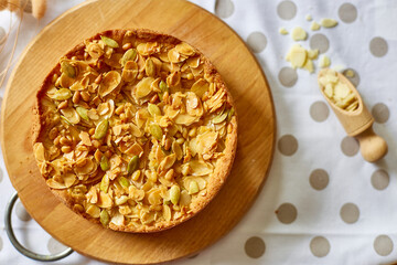 Apple or pear pie, tart with caramel nuts on wooden table, copy space, top view.