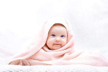 Cute baby with towelthree month old blue-eyed girl wrapped in a terry towel