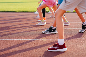 Close-up of the legs of boys and girls, at the start before running and playing sports at the...
