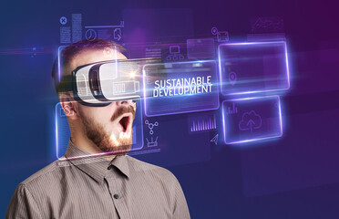 Businessman looking through Virtual Reality glasses, tech concept