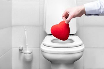 the hand that throws the heart into the toilet trash. a symbol of broken love and separation....